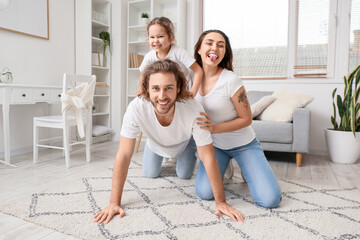 Happy young family on carpet at home