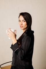 Portrait of pretty  woman holding a coffee mug at home