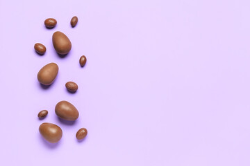 Delicious chocolate eggs on purple background