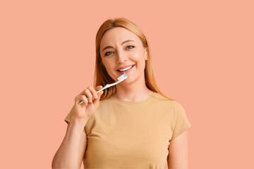 Beautiful mature woman brushing teeth on color background