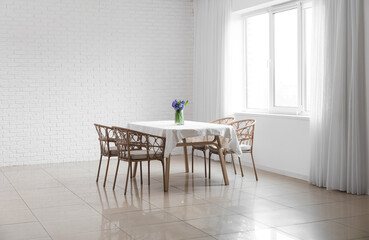 Dining table with flowers and chairs in big light room