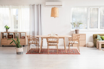 Interior of light dining room with table and vintage carpet