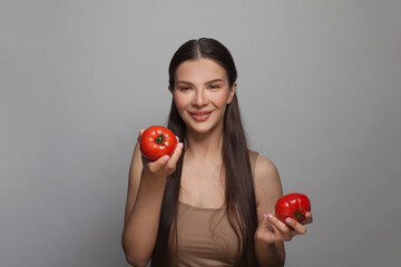 Happy woman holding tomatoes for veggie health and good nutrition