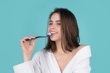 Young woman brushing teeth. Happy funny girl brush her teeth on isolated background. Beautiful wide smile of young woman with great healthy white teeth.