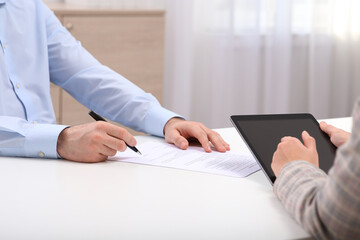 Businesspeople signing contract at white table in office, closeup of hands