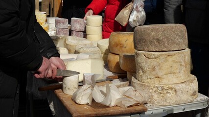 Farmers Market in an outdoor space filled with stalls offering artisan cheese