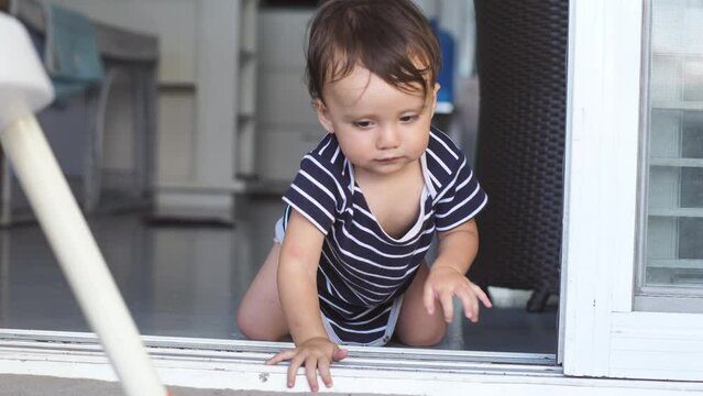 Smart A toddler less than a year old opens the door on his own, climbs over the threshold, and then tries to close the door behind him. The development of kids and their desire to know the world.