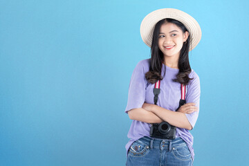 Asian woman with hat and camera standing