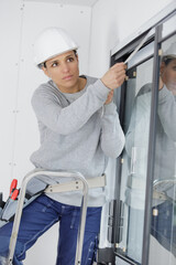 female glazier installing window trim