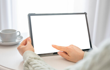 Mockup tablet. Woman hand touch tablet with blank empty screen. woman sitting at round white table and hold mockup tablet with white blank screen. high key