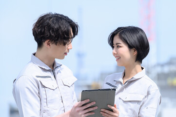 Obraz premium 作業着姿で相談する二人 見つめ合う