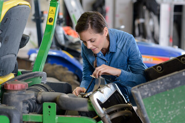 woman checking oil level on professional lawnmower