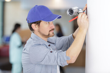 contractor installing a discreet security camera in a hospital