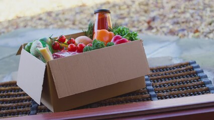 Box of fresh ingredients for online meal recipe kit delivered to home on doorstep - shot in slow motion