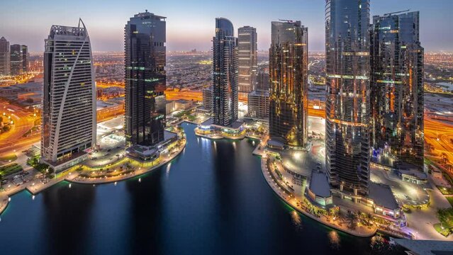 Tall residential buildings at JLT aerial night to day timelapse, part of the Dubai multi commodities centre mixed-use district.