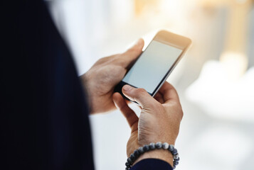 Keeping business mobile. Cropped shot of a businessman using a mobile phone in a modern office.