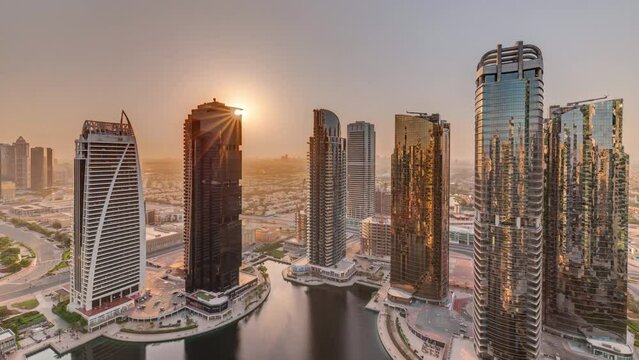 Sunrise over tall residential buildings at JLT aerial timelapse, part of the Dubai multi commodities centre mixed-use district.