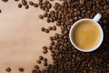 Small white coffee cup with espresso crema on roasted beans at brown background. Mock up