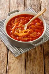 Cebolada is a Portuguese onion stew, onion sauce or paste that is prepared with onion as a primary ingredient close-up in the pot on a wooden table. Vertical