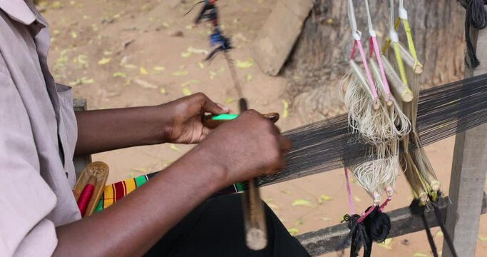 Handmade loom man making Kente cloth fabric Accra. Ghana, where the traditional cloth in Africa, Kente is made on hand looms, hand woven. The Kente is worn by the king of the Ashanti Kingdom. Complex.