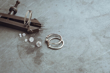 Jewelry production concept. Silver ring with gemstone on jeweler's workbench. Workplace of a...