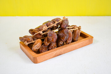 dried dates fruit on wooden plate for ifthar ramadhan and ied fitr