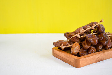 Tunisia dried dates fruit on wooden plate for ifthar ramadhan and ied fitr. White Background