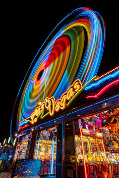 Grande roue qui tourne devant un casino dans un f&ecirc;te foraine de nuit. 