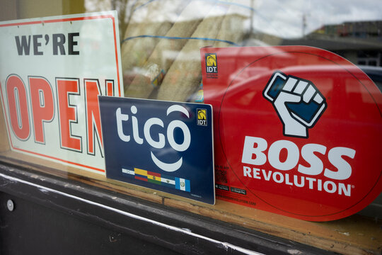 Beaverton, OR, USA - Mar 18, 2022: Tigo and IDT's Boss Revolution signs are seen at a grocery store in Beaverton, Oregon. IDT Corporation is a global provider of communications and payment services.