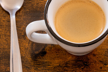 cup of coffee and spoon on wooden table
