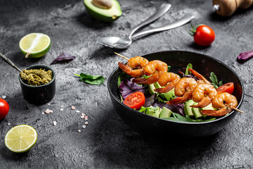 Vegetarian vegetable low carb lunch bowl with avocado, fresh salad, grilled shrimps and pesto...