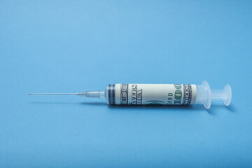 A syringe wrapped in a dollar.