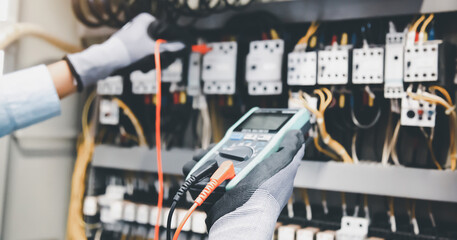 Electrical engineer using digital multi-meter measuring equipmen