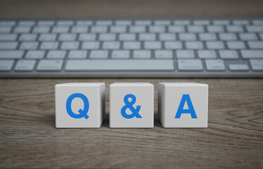 Q and A letter on white block cubes on wooden table with computer keyboard, Frequently asked...
