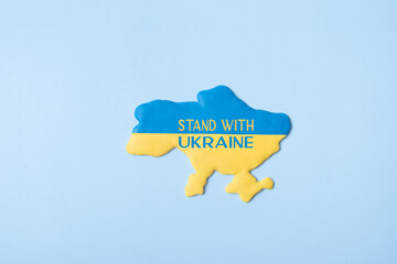Stand with Ukraine text on tha map Ukraine in yellow-blue colors of the national flag on a blue...