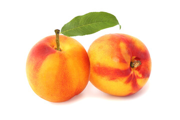 Two nectarines with leaf isolated on white