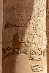 Massive columns inside beautiful Egyptian temple in Luxor with hieroglyphics, and ancient symbols. Karnak temple.