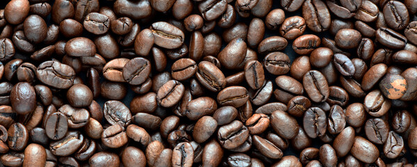 Fresh coffee beans scattered as a background or texture.