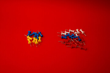 Pushpins, country flags, war on a red background