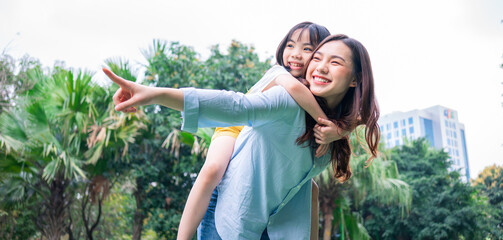 Asian mother and daughter playing together at park