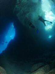 cave diving underwater scuba divers exploring caves and having fun ocean scenery sun beams and rays background
