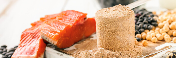 Protein and ingredients on a light wooden table. The products containing a protein. Sports food. Selective focus.