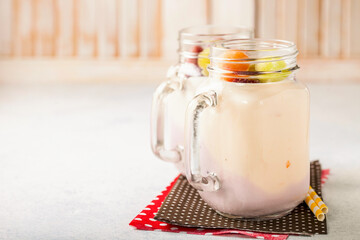 Yogurt and the frozen fruit in glasses on a light background. Selective focus. Copy space