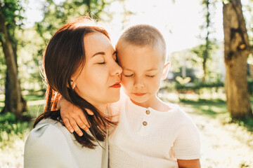 Mother and little son portrait in park.