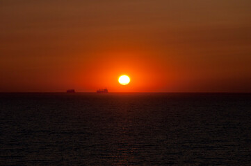 sundown sky and sea with ship on horizon, bali
