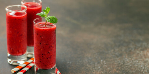 Strawberry smoothies in a glass on a dark  background. Selective focus. Copy space