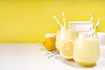Creamy lemon fruit smoothie, yogurt ar milkshake, Sour sweet drink with fresh lemons on white yellow background copy space