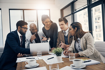 Business collaborations are what theyre best at. Shot of a group of young businesspeople using a laptop together during a meeting in a modern office.