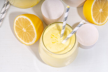 Creamy lemon fruit smoothie, yogurt ar milkshake, Sour sweet drink with fresh lemons on white yellow background copy space