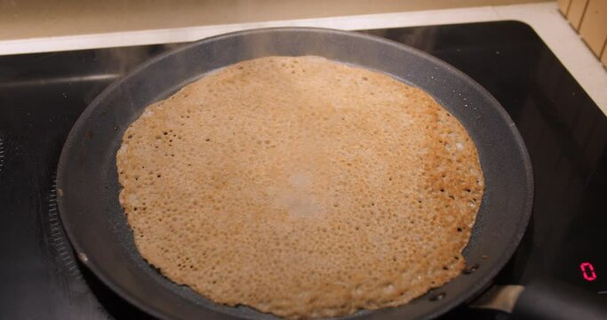 Buckwheat Pancake Cooking On A Hot Cast Iron Frying Pan. Galette de Sarassin. close up